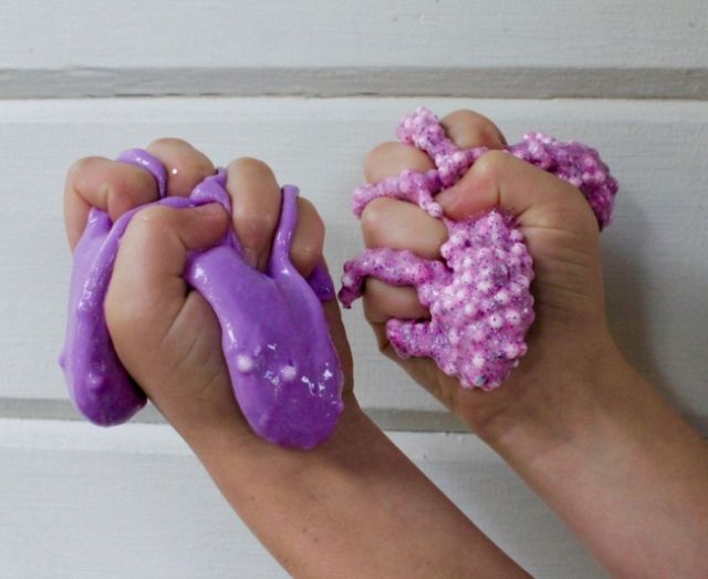 Фиолетовый и сиреневый слайм в руках